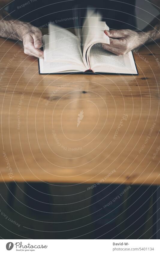 in einem Buch lesen / etwas nachschlagen anonym blättern Bildung lernen Mann Hände Wissen Tisch