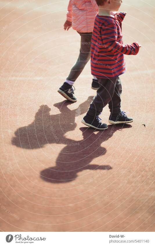 Kinder mit Schatten - gemeinsam zusammen Freundschaft Geschwister Freunde Kindheit Mädchen Junge Bruder Schwester spazieren