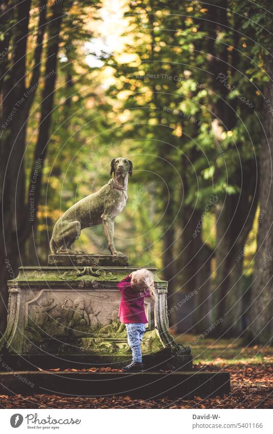 Kleinkind betrachtet ehrführchtig eine Statue Ehrfurcht Kind niedlich erkunden neugierig fasziniert beeindruckt Mädchen Vergangenheit Hund beobachten Kindheit