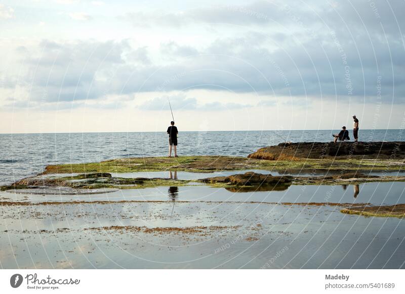 Anglern im Sommer bei Wolken und Sonnenschein am Rosa Felsen an der Küste des Schwarzen Meer in Kefken in der Provinz Kocaeli in der Türkei angeln angelsport