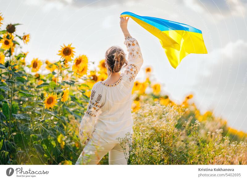 Junge ukrainische Frau winken nationale Flagge auf Sonnenblumen, Weizenfeld Hintergrund Freiheit Mädchen Selbstständigkeit Nation im Freien Patriotin