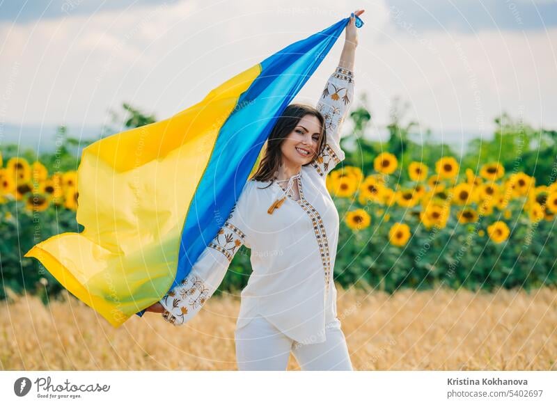 Junge ukrainische Frau winken nationale Flagge auf Sonnenblumen, Weizenfeld Hintergrund Freiheit Mädchen Selbstständigkeit Nation im Freien Patriotin