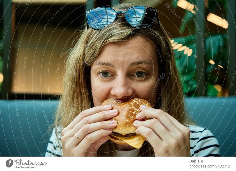 Frau isst Burger, Nahaufnahme Porträt hungrig Essen Hamburger geschmackvoll Lebensmittel Fastfood nahrhaft Biss Erwachsener attraktiv schön Kalorien lecker
