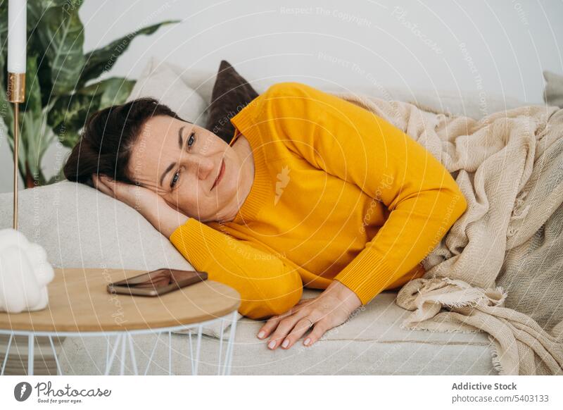 Reife Frau auf Sofa ruhend Windstille Mittagsschlaf sich[Akk] entspannen Wohnzimmer heimwärts Komfort Liege Gelassenheit Lügen ruhig Kälte friedlich lässig