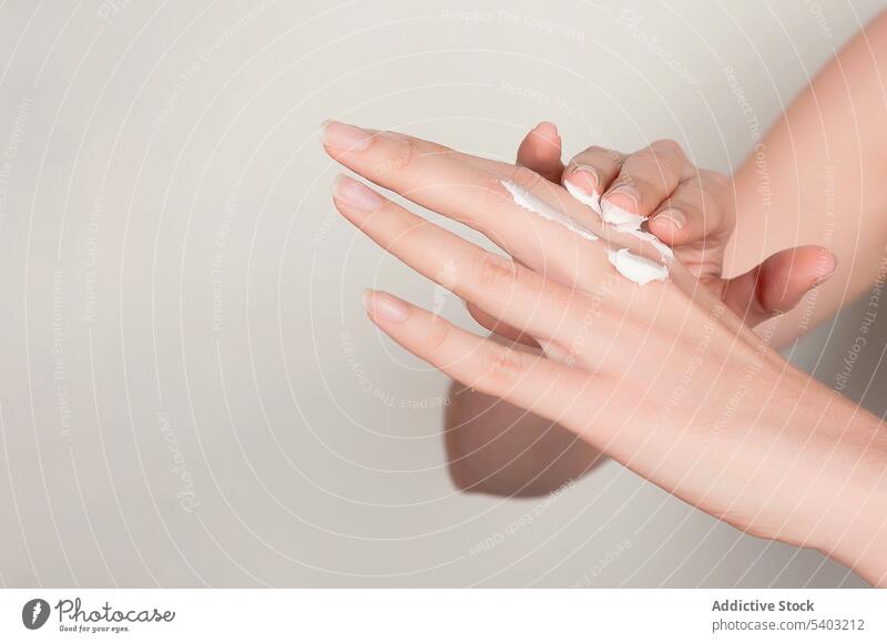 Unerkennbare Erntefrau, die Kosmetikcreme auf die Hände aufträgt Frau Hand Sahne bewerben Hautpflege Feuchtigkeit Finger Leckerbissen verjüngen Kosmetologie