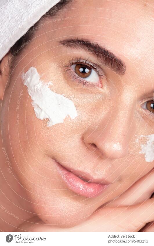 Glückliche Ernte junge Frau mit weißer Gesichtsmaske und Creme Hautpflege Mundschutz Lächeln Sahne Verfahren Kosmetik bewerben Handtuch Feuchtigkeit
