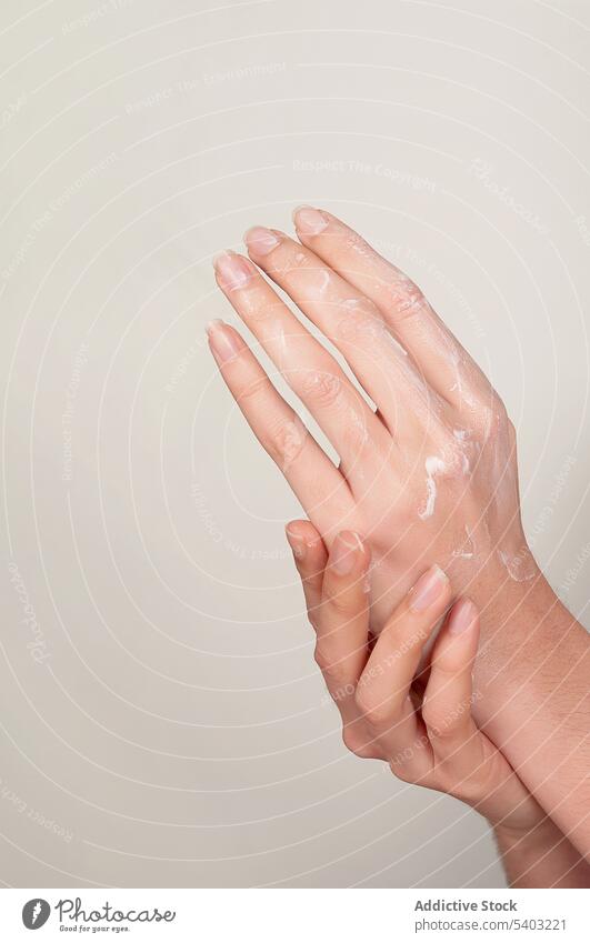 Unerkennbare Frau, die sich die Hände mit Kosmetikcreme eincremt Hand Sahne bewerben Hautpflege Feuchtigkeit Finger Leckerbissen verjüngen Kosmetologie Produkt