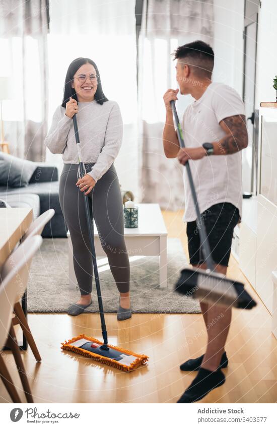 Junges Paar hat Spaß beim Putzen des Hauses Appartement Kaukasier Sauberkeit zurechtmachen Raumpfleger Reinigen Tanzen dreckig Desinfektion heimisch Frau lustig