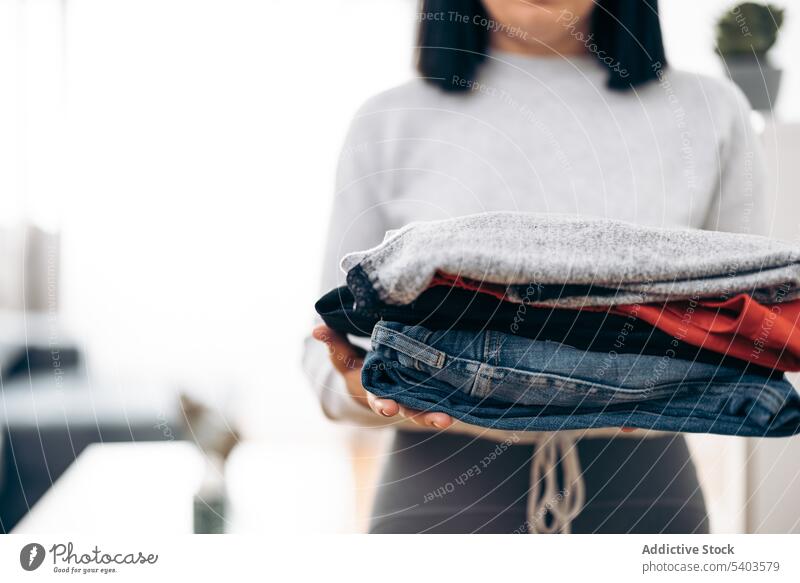Unbekannte Frau trägt gefaltete Kleidung tragen Sauberkeit Bekleidung Baumwolle heimisch Pferch Hand Haufen Hausfrau Hausarbeit Wäscherei Material vorbereitend