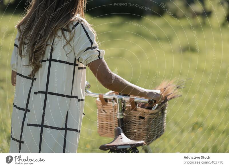 Anonyme junge Frau mit Fahrrad auf dem Lande Feld Landschaft Natur lässig Aktivität Lifestyle Gras Spaziergang frisch ländlich Sommerzeit sorgenfrei aktiv