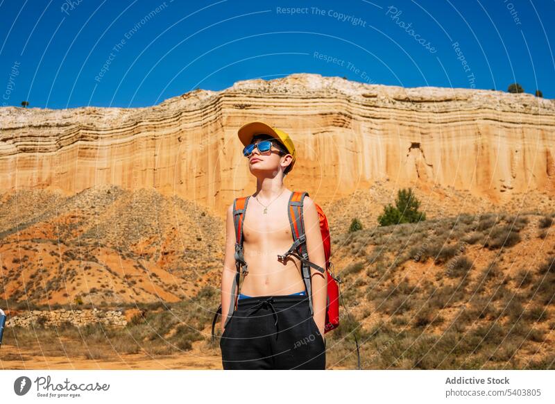 Jugendlicher mit Sonnenbrille und Rucksack in der Wüste Junge Reisender Tourist Abenteuer Kind Schlucht Urlaub Berge u. Gebirge Hügel Klippe rojo teruel reisen