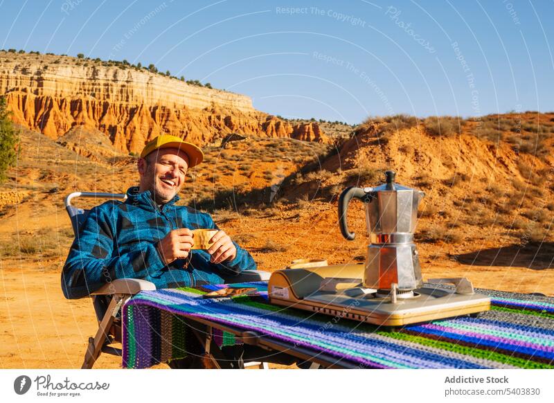 Mann trinkt heißes Getränk in einer Bergschlucht trinken Kaffee ruhen Lager Tourist Tasse Schlucht Wasserkessel Heißgetränk Stuhl wüst Abenteuer Morgen