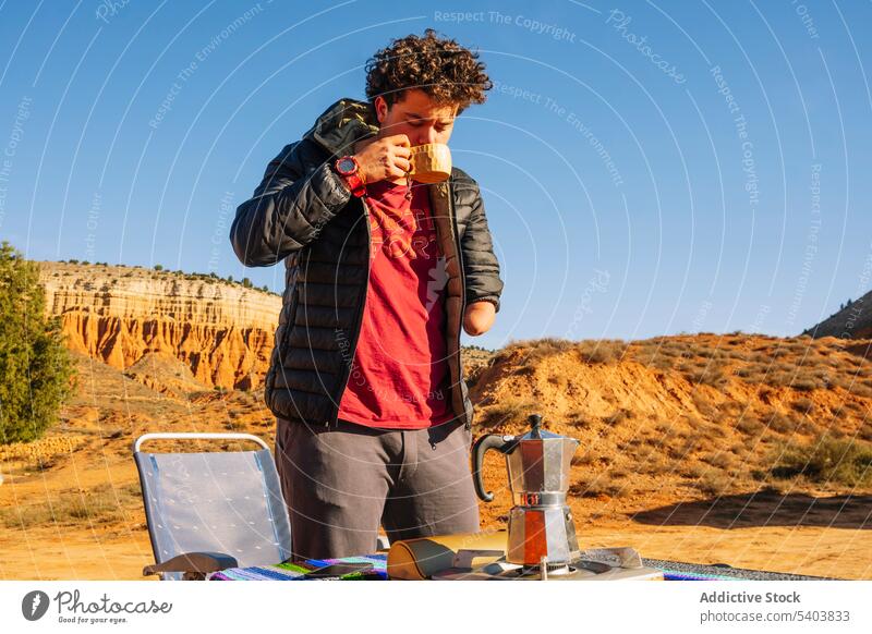 Mann mit amputiertem Arm trinkt Heißgetränk auf einem Campingplatz Kaffee Natur reisen Tourist Urlaub Tourismus Amputierte Morgen Reisender Getränk Freiheit