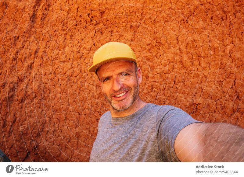 Fröhlicher Mann mit Mütze macht Selfie in der Nähe der Canyon-Wand Lächeln Porträt Tourist Urlaub Schlucht Tourismus Reisender Verschlussdeckel Abenteuer