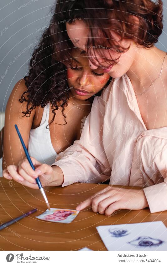 Lesbische Paar Färbung Bild auf Papier zu Hause lesbisch zeichnen Zusammensein Pinselblume Frauen Freundin Tisch heimwärts multiethnisch rassenübergreifend