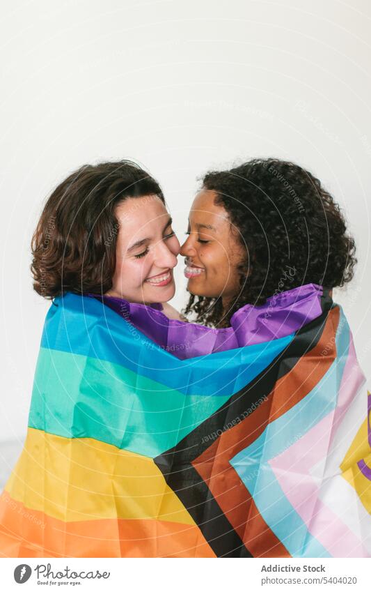 Glückliche junge Freunde mit LGBT-Flagge lesbisch Paar Fahne lgbt Partnerschaft Liebe Augen geschlossen Umarmung Lächeln Umarmen Frau vielfältig multiethnisch