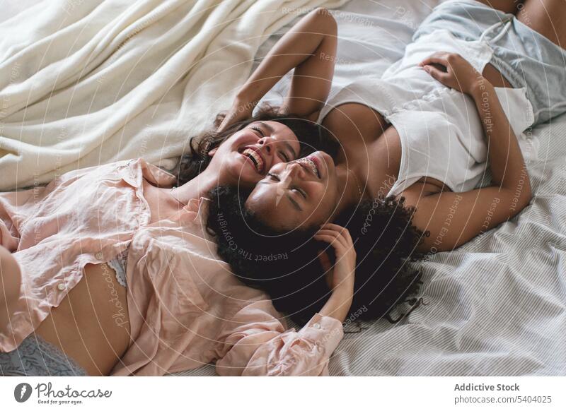 Von oben von diversen verliebten Freundinnen auf dem Bett liegend Paar lesbisch Partnerschaft Liebe romantisch sich[Akk] entspannen Decke Lügen