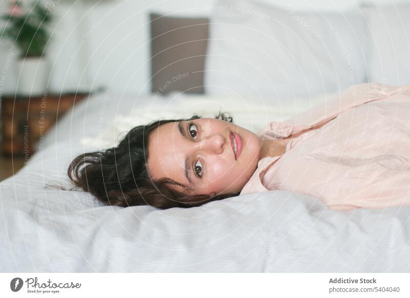 Zufriedene junge Frau, die sich zu Hause im Bett entspannt Lächeln Porträt ruhen Glück Lügen Komfort heimisch sich[Akk] entspannen Schlafzimmer Morgen heimwärts