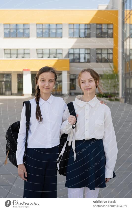 Glückliche junge Schulmädchen auf einem Gelände Schüler Teenager Klassenkamerad Uniform Jugendlicher Lächeln Freund Pupille Schule Mädchen positiv Zusammensein