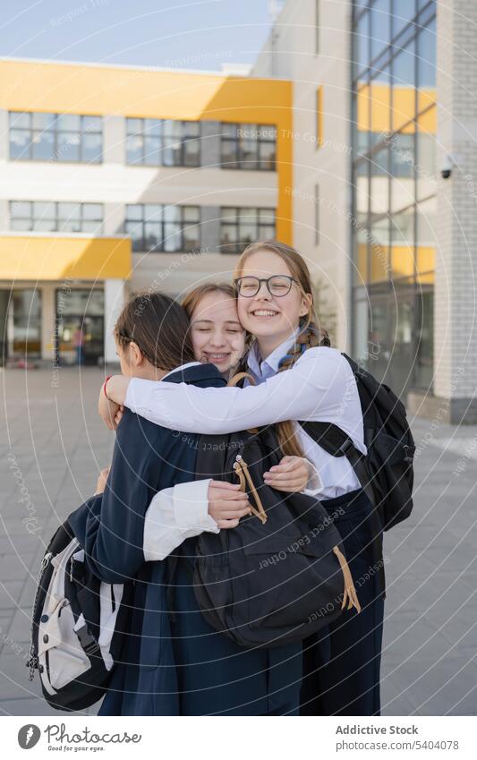 Glückliche junge Mädchen im Teenageralter, die sich auf dem Schulcampus umarmen Umarmung Freund Klassenkamerad Jugendlicher Schüler Schulmädchen Gebäude Lächeln
