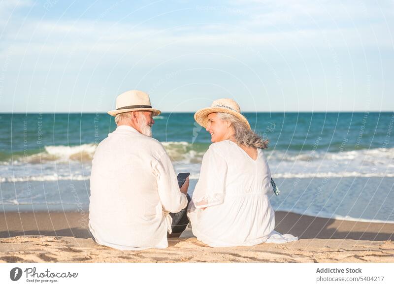 Romantisches Seniorenpaar an der Küste Paar Liebe Strand romantisch Sonnenuntergang Zusammensein Urlaub schließen Sommer Strohhut älter Mobile Meeresufer Abend