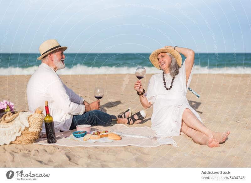 Älteres Paar genießt Picknick am Strand Schal Weinglas Klirren Zuprosten Liebe Glück Partnerschaft Zusammensein romantisch MEER Feiertag Zuneigung trinken