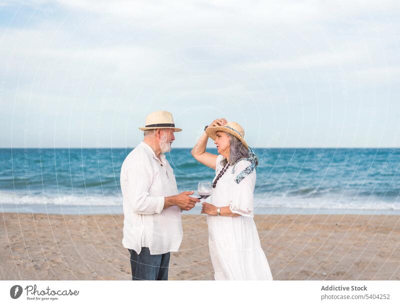 Entspanntes Seniorenpaar mit Wein am Strand Paar Freizeit romantisch Meer MEER zuhören Partnerschaft Zusammensein trinken Urlaub Sommer Liebe idyllisch gealtert
