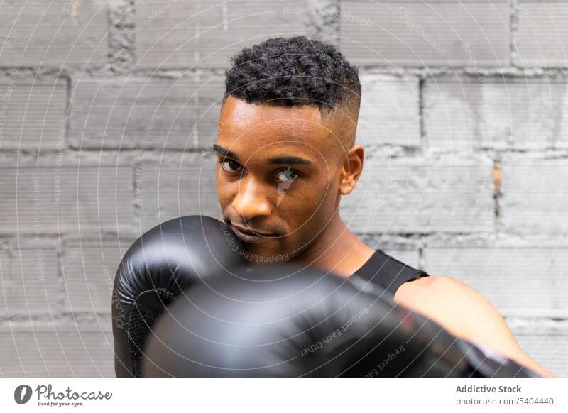 Schwarzer Sportler kämpft in moderner Turnhalle Boxer kämpfen Bowle Training Fitnessstudio Sportbekleidung Handschuh Leder Porträt männlich schwarz