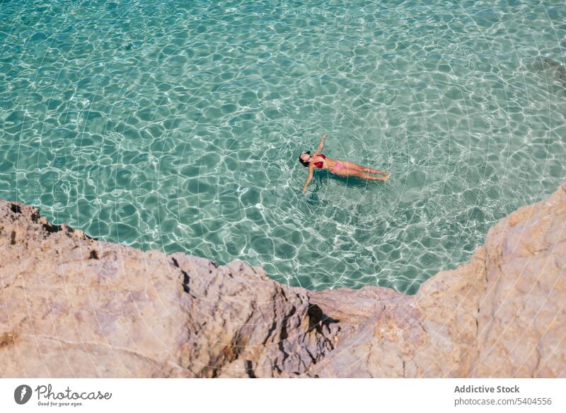 Junge Frau beim Schwimmen im blauen Ozean von oben Tourist Bikini schwimmen Schwimmer türkis MEER Meer tropisch Resort Balearen Badebekleidung Badeanzug