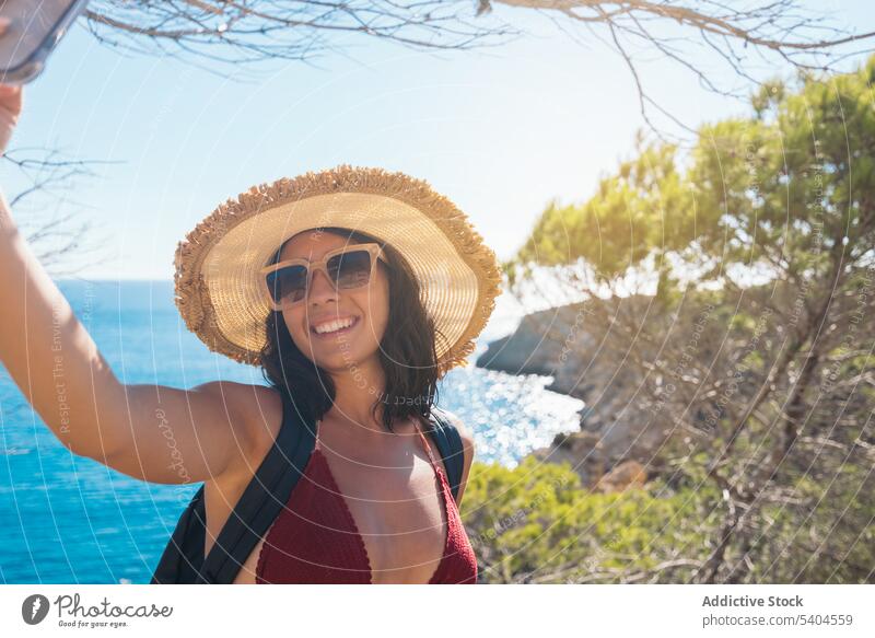 Junge Frau nimmt Selfie mit Meer Tourist Smartphone Selbstportrait MEER tropisch Resort Hut Balearen fotografieren Bild Gedächtnis Mobile Tourismus reisen