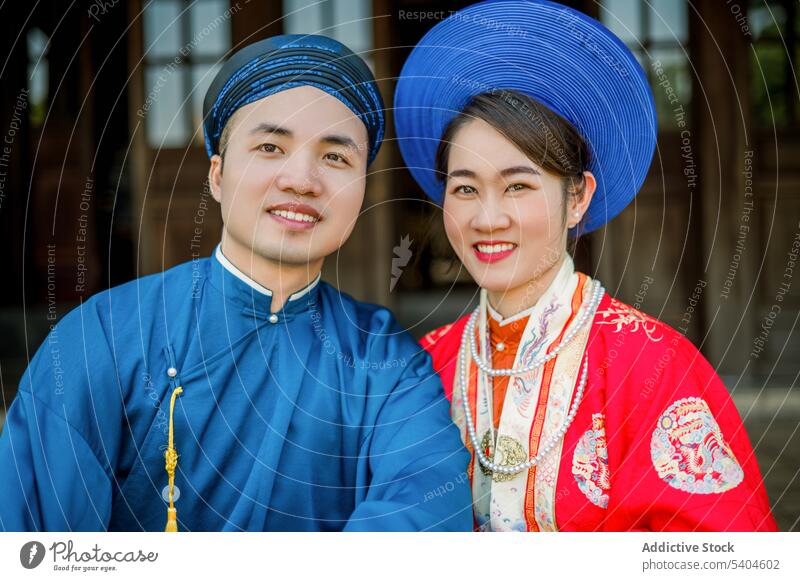 Glückliches asiatisches Paar verbringt Zeit miteinander Partnerschaft Porträt Tradition traumhaft Stil Kleidung Lächeln Zuneigung Veranda authentisch Haus