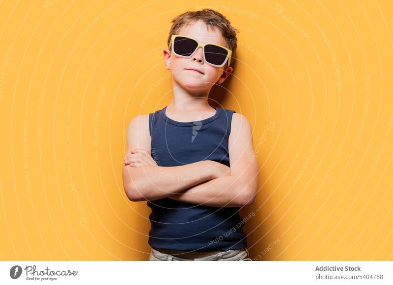 Stylischer Junge mit Sonnenbrille und verschränkten Armen im Studio Stil trendy Porträt Tanktop die Arme verschränkt selbstbewusst cool Einstellung Youngster