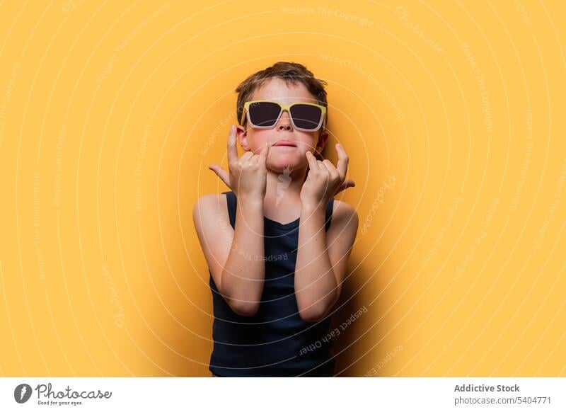 Cooler Junge mit Sonnenbrille und Rock'n'Roll-Zeichen cool Rock and Roll auflehnen Hupe Rocker Stil Kind gestikulieren zeigen Symbol Accessoire Tanktop