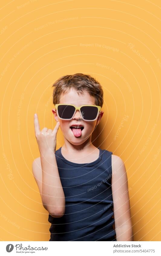 Cooler Junge mit Sonnenbrille zeigt Rock'n'Roll-Schild cool Rock and Roll auflehnen Hupe Zeichen Rocker Stil Kind gestikulieren zeigen Symbol Accessoire Tanktop