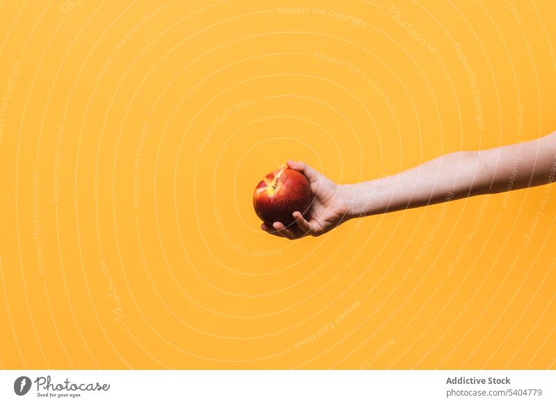 Crop Kind mit Apfel über gelben Hintergrund Frucht frisch Hand zeigen Gesundheit lecker Lebensmittel Vitamin reif organisch natürlich süß Ernährung essbar