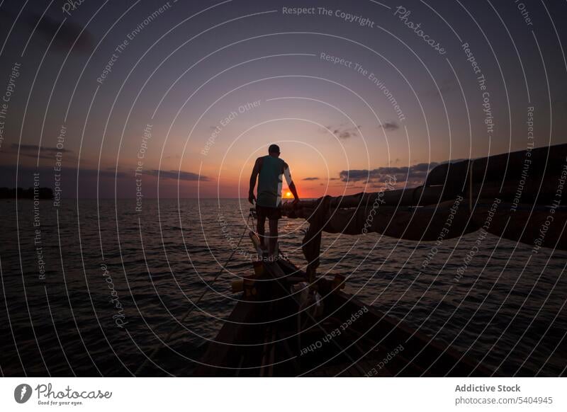 Silhouette eines Mannes auf einem Boot im Meer bei Sonnenuntergang Jacht MEER bewundern Natur Saum Himmel Wasser erkunden genießen Küste reisen Reisender