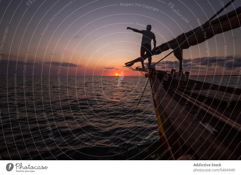 Silhouette eines Mannes auf einem Boot im Meer bei Sonnenuntergang Jacht MEER bewundern Natur Saum Himmel Wasser erkunden genießen Küste reisen Reisender