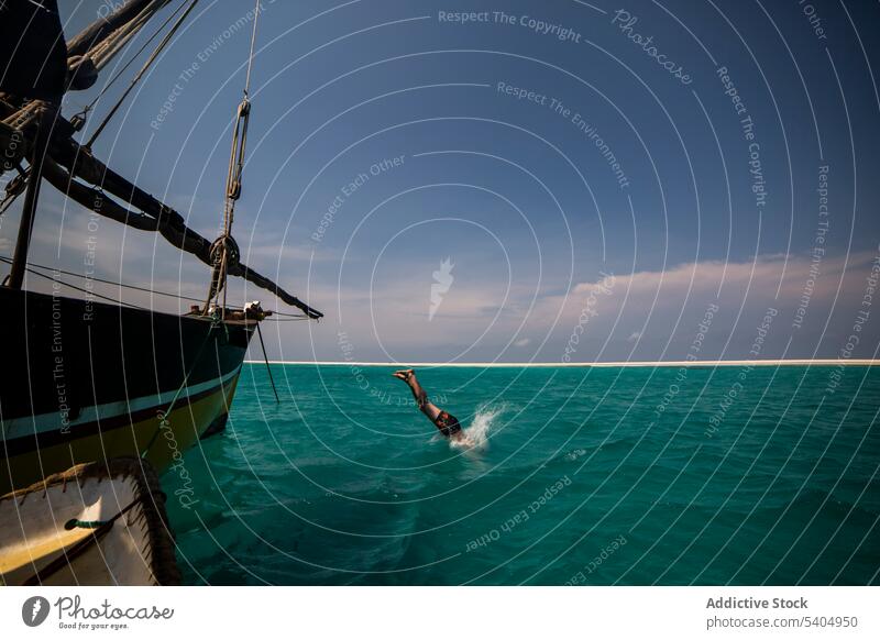 Mann taucht von Yacht ins Meer MEER Sinkflug Segelboot Aktivität schwimmen wolkig Wasser marin Boot Neoprenanzug aqua malerisch Badeanzug Himmel Natur