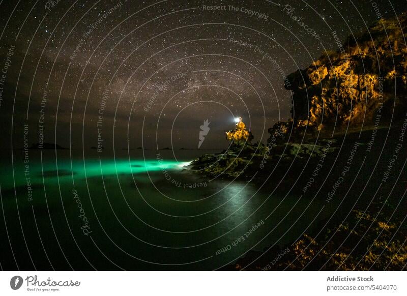 Erstaunliche sternenklare Nacht über der Küste mit leuchtendem Leuchtturm Ufer Insel Meer Landschaft Natur glühen MEER Leuchtfeuer Galaxie Meeresufer