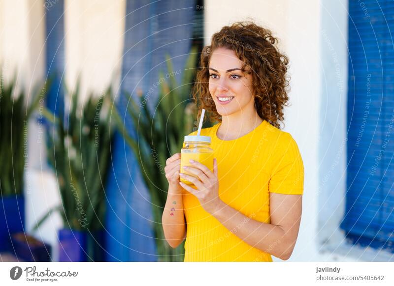 Lächelnde Frau mit erfrischendem Getränk lächelnd auf der Straße Saft trinken Glück orange Gesundheit Sommer Café positiv heiter jung Stroh Glas Erfrischung