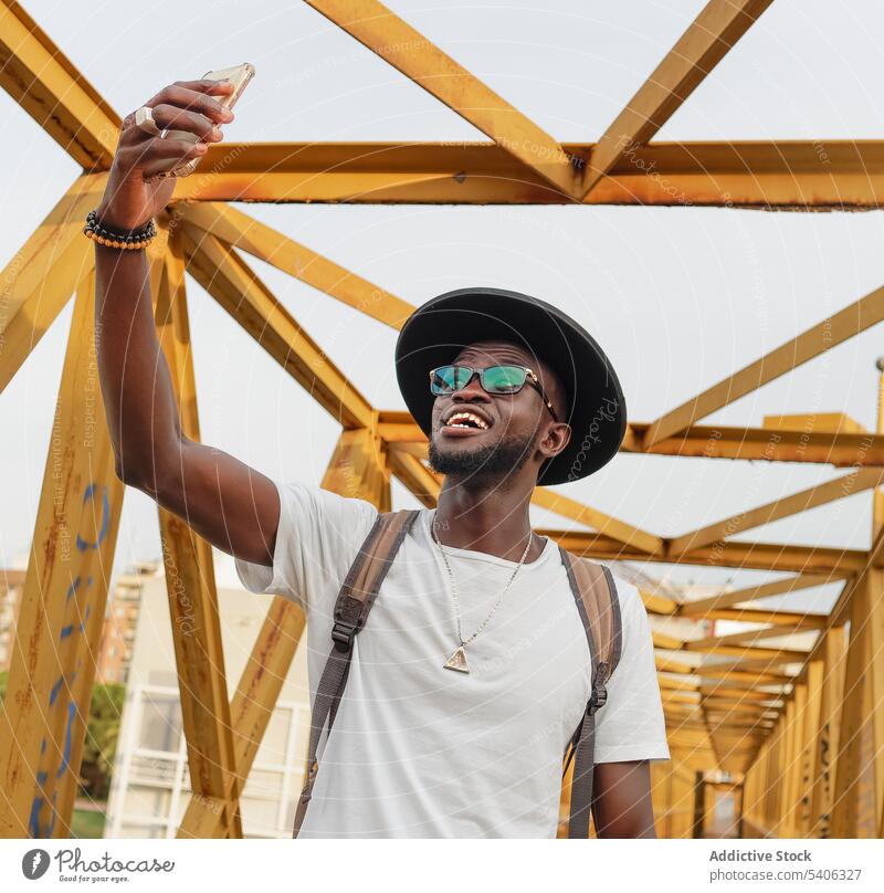 Stilvoller schwarzer Mann nimmt Selfie auf Brücke Tourist Smartphone cool Straße Großstadt Selbstportrait männlich Afroamerikaner Mobile gutaussehend ethnisch
