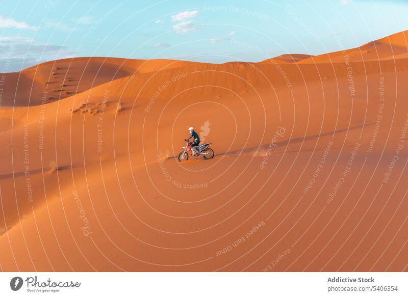 Unerkennbarer Reisender fährt Fahrrad in der Wüste Person Mitfahrgelegenheit Motorrad wüst Sand Düne Abenteuer Biker Verkehr extrem Sport Marokko Himmel