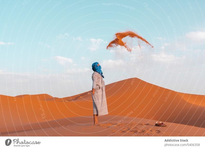 Anonymer Berbermann wirft in der Wüste Sand in die Luft Mann muslimisch werfen wüst Tradition tuareg Düne trocken Marokko Merzouga männlich Natur reisen Afrika