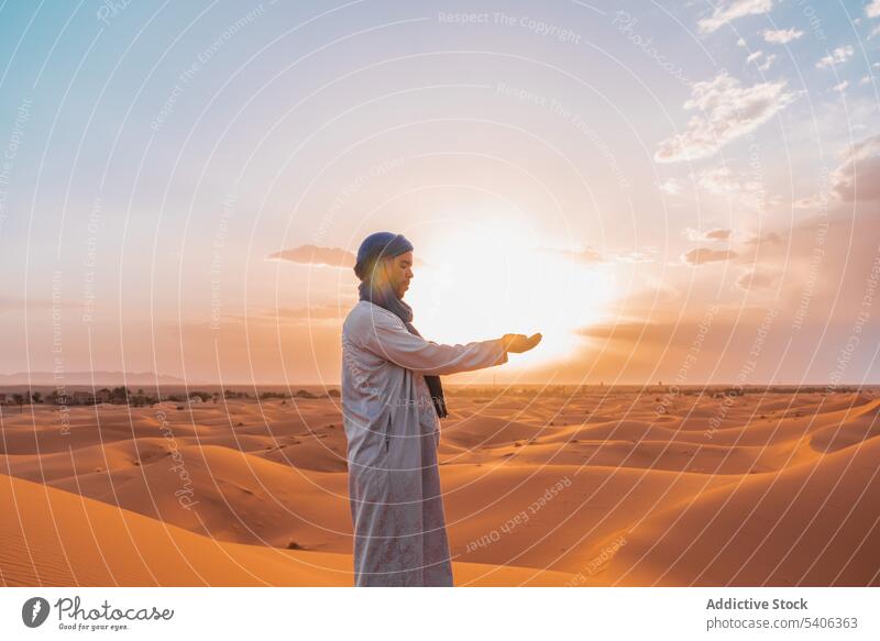 Muslimischer Mann mit verbundenen Händen in der Wüste stehend Sand Düne Berber Tradition Hände gefaltet wüst muslimisch Natur Sonnenuntergang Merzouga Marokko