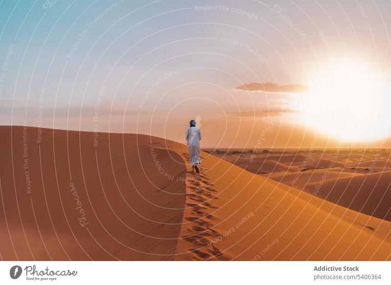 Anonymer Berber, der in der Wüste auf Sand läuft Mann Spaziergang Fußspur Düne wüst Sonnenuntergang Natur reisen Merzouga Marokko Landschaft Reisender Person