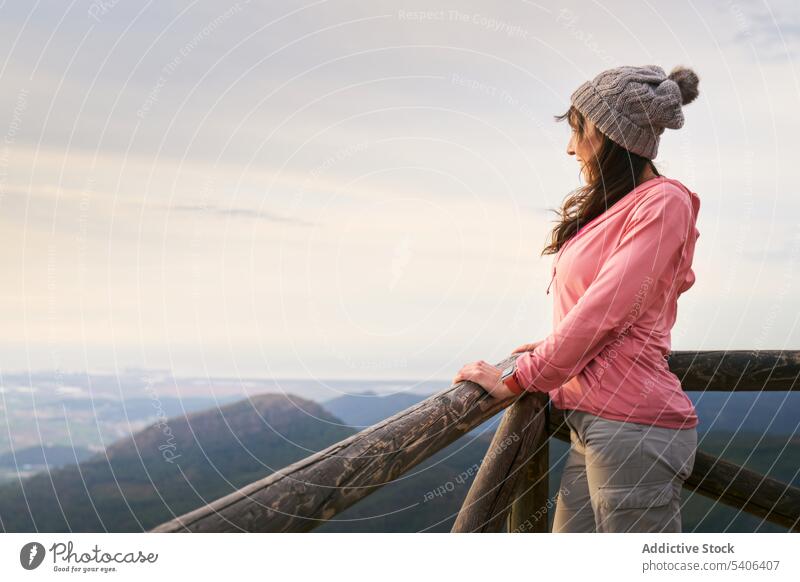 Fröhliche Frau lehnt an einem Zaun in den Bergen Tourist Reisender Berge u. Gebirge Reling bewundern Hochland beobachten Urlaub Aussichtspunkt Ausflug reisen