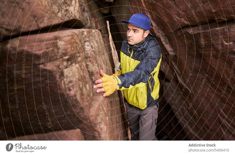 Tourist in engem Spalt einer Höhle Mann Lücke Ausflug Durchgang felsig erkunden Formation Aufstieg männlich Reisender Berge u. Gebirge Urlaub reisen Tourismus