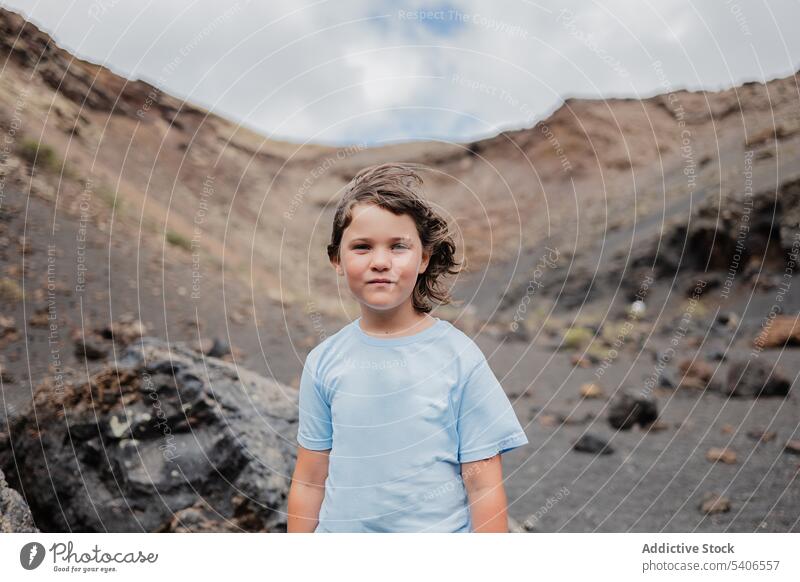 Nachdenkliches Kind, das auf einer Felsformation in einer bergigen Gegend steht ernst Formation Stein Felsen Felsbrocken genießen Blauer Himmel besinnlich