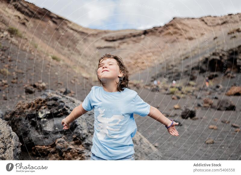 Glückliches Kind, das auf einer Felsformation in einem Gebirge steht Lächeln Formation Stein Felsen Felsbrocken genießen Blauer Himmel Inhalt Sommer Mädchen