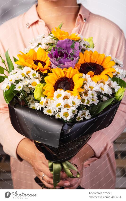 Crop-Frau mit Blumenstrauß Blumenhändler Geschenk präsentieren Haufen umhüllen aromatisch Flora Blütezeit Pflanze frisch geblümt Stil feiern Laden Floristik